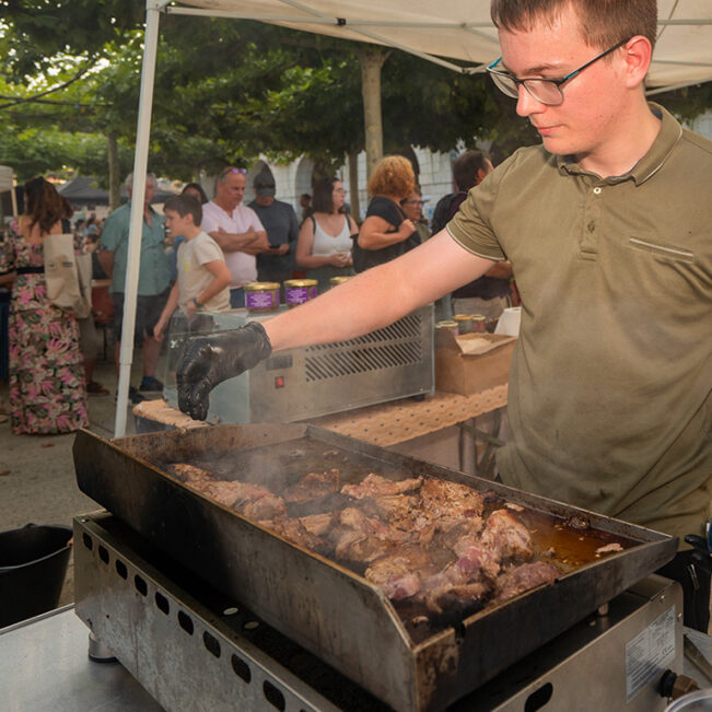 Producteur local faisant cuire de la viande issue de sa ferme pour préparer un plat à l'un des marchés des producteurs de pays de Lacq-Orthez.