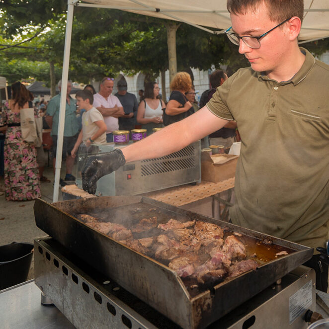 Producteur local faisant cuire de la viande issue de sa ferme pour préparer un plat à l'un des marchés des producteurs de pays de Lacq-Orthez.