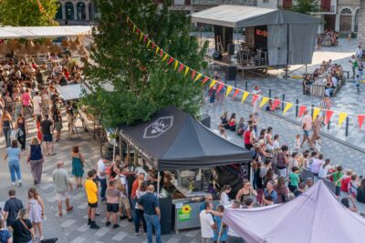 Foule attendant le concert sur scène place de l'Église et d'autres près des stands d'artisans et commerçants. - Agrandir l'image 1 sur 3, fenêtre modale