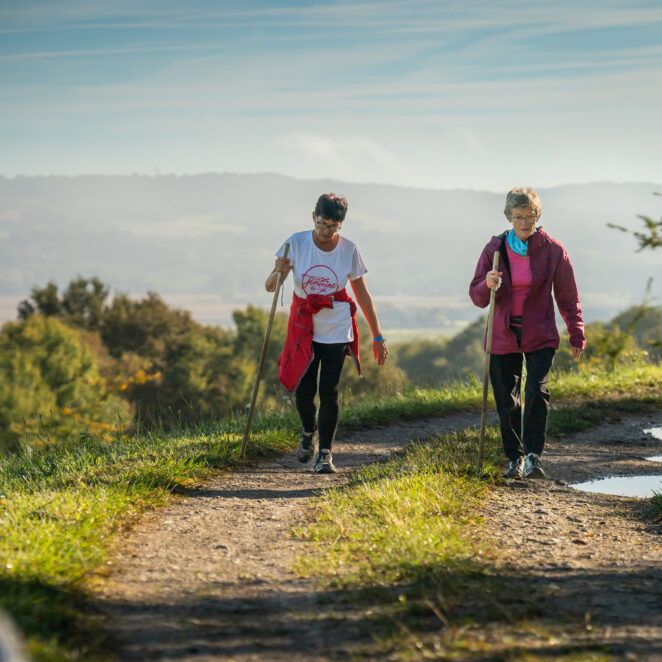 Deux randonneuses sur un chemin de randonnée à Maslacq avec une vue panoramique en toile de fond.