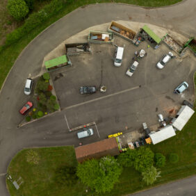 Déchetterie de Maslacq vue du ciel avec plusieurs voitures garées le coffre ouvert afin de déposer leurs déchets dans les bacs de tri.