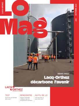 Page de garde du LO Mag avec écrit en haut à gauche LO MAG, une photo au centre à cheval sur un rectangle blanc à gauche et un rectangle rouge à droite, dans laquelle on distingue plusieurs salariés habillés en tenue de chantier, de dos, se dirigeant vers l'intérieur de grandes usines qui se dressent de part et d'autre de la photo sous forme de grand tubes. Le bas de la page de garde montre 3 sections "test pour savoir quel trieur de déchets êtes-vous", "rencontre avec l'université" et "au fil de LO une seconde vie pour votre ordi" pour teaser l'intérieur du magazine. - Agrandir l'image, fenêtre modale