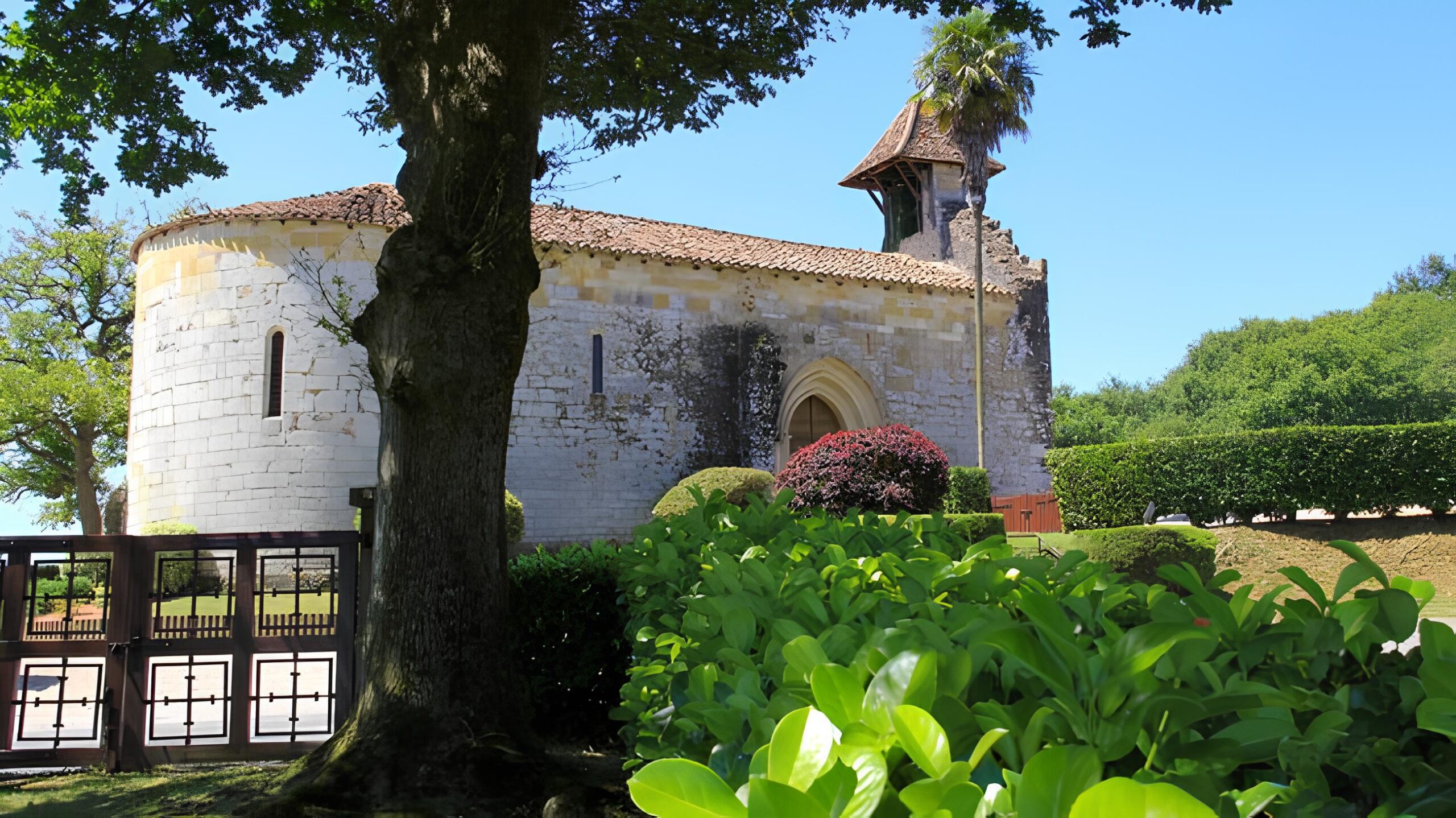 Vue de la chapelle de Caubin avec une tour légèrement en ruines, visible depuis les jardins très bien taillés. - Agrandir l'image, fenêtre modale