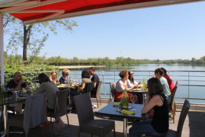 Plusieurs tables abritées en terrasse au bar-restaurant Le Louisabella situé face au Lac de Biron. - Agrandir l'image 4 sur 5, fenêtre modale