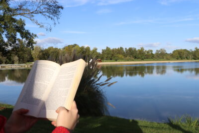 Personne lisant un livre face au lac de Biron à la Base de loisirs. - Agrandir l'image 2 sur 2, fenêtre modale