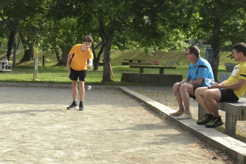 Jeune adolescent lançant sa boule de pétanque lors d'une partie lancée durant les Olympiades de la Fête du lac. - Agrandir l'image, fenêtre modale