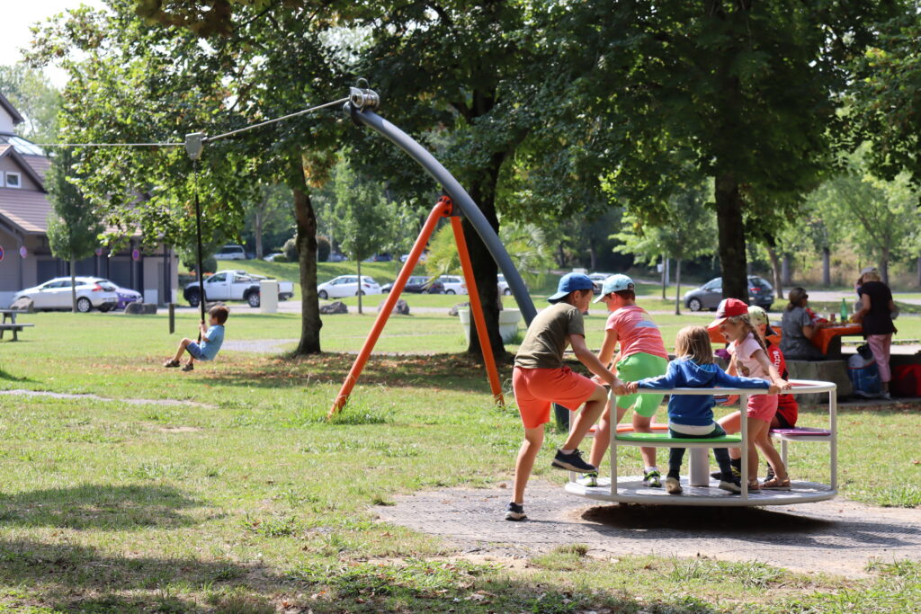Enfants jouant à plusieurs au tourniquet de l'aire de jeux de la Base de loisirs. - Agrandir l'image, fenêtre modale