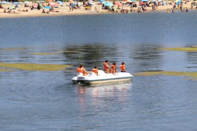 Groupe de vacanciers avec des gilets de sauvetage profitant d'un pédalo blanc de location sur le lac près de la plage. - Agrandir l'image 2 sur 5, fenêtre modale
