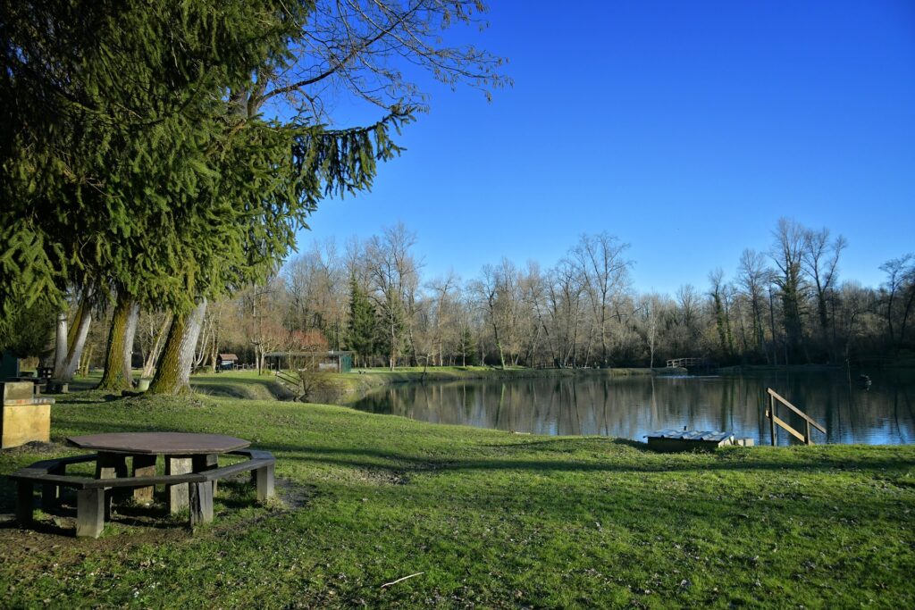 Vue panoramique d'un lac avec aux abords, des tables de pique-nique en très bon état. - Agrandir l'image, fenêtre modale