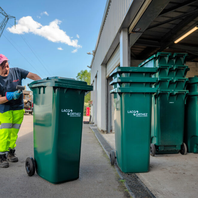 Un agent du service déchets rangeant des bac à déchets dans l'une des déchetteries du territoire.