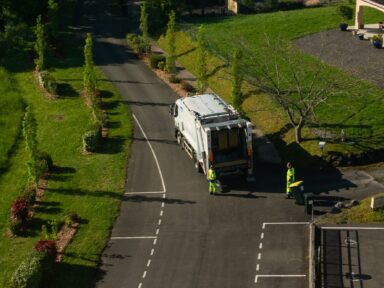 Agents du service déchets pendant leur tournée de collecte des emballages ménagers devant des habitations à Lacadée.