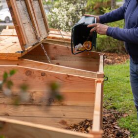 Habitant d'Orthez vidant ses déchets alimentaires dans un bac prévu pour le compost