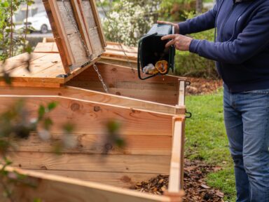 Habitant d'Orthez vidant ses déchets alimentaires dans un bac prévu pour le compost