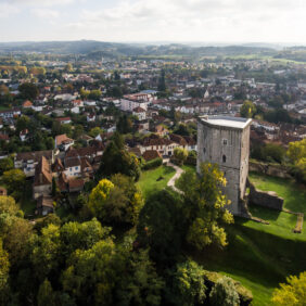 Vue du ciel d'un quartier d'Orthez avec de la verdure et la Tour Moncade qui surplombe la ville.
