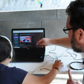 Un médiateur numérique guidant une jeune fille pour lui apprendre à se servir de son ordinateur et la sensibiliser aux usages.