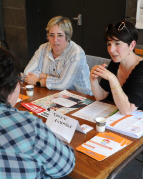 Deux conseillères en recrutement échangent avec une dame sur les formations existantes sur le territoire et les domaines qui recrutent.
