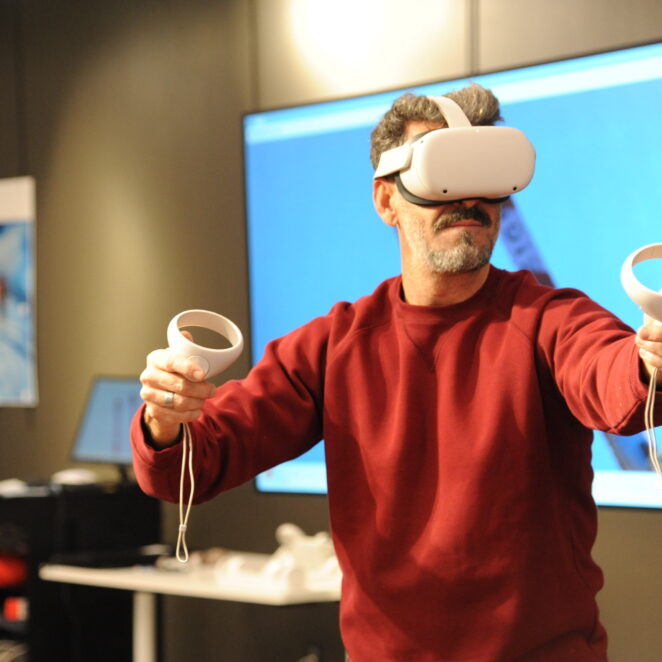 Homme jouant avec un casque et des manette adaptés aux jeux en réalité virtuelle.
