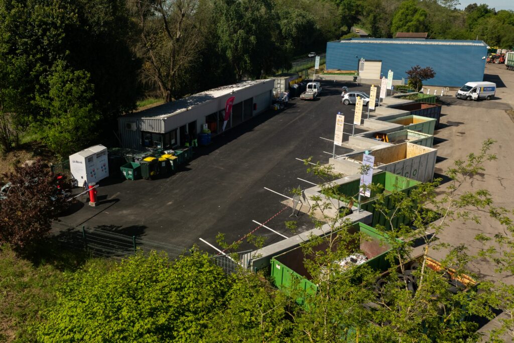 Vue du ciel de la déchetterie d'Orthez avec le goudron entièrement refait face à nous, la route étant verticale, et les 7 bennes de tri flambant neuves à droite, après les travaux. - Agrandir l'image, fenêtre modale