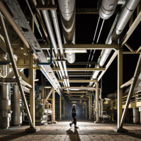 Salarié marchant dans une grande salle de tuyauterie de l'industriel Air Liquide.