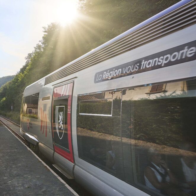 Un TER floqué avec l'identité de marque de la Région Nouvelle-Aquitaine, s'élançant à toute vitesse sur les rails