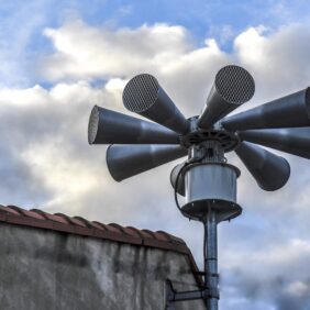 Zoom sur la sirène d'alerte SAIP sur le toit d'un bâtiment et ses 8 mégaphones pour la faire retentir.