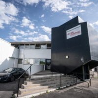 Façade de la pépinière d'entreprises à Artix avec un grand panneaux qui annonce ce qu'est l'établissement.