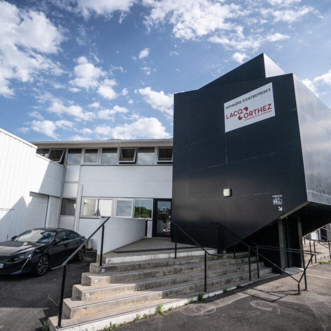 Façade de la pépinière d'entreprises à Artix avec un grand panneaux qui annonce ce qu'est l'établissement.