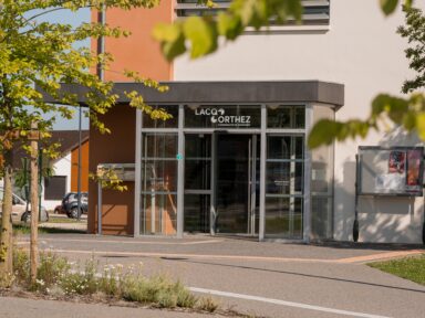 Façade de l'antenne de la collectivité à Orthez avec le logo de la collectivité sur la vitre de la porte d'entrée.