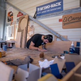 Jeune homme travaillant le bois avec un casque de chantier pour faire des créations 100 % faites à la main.