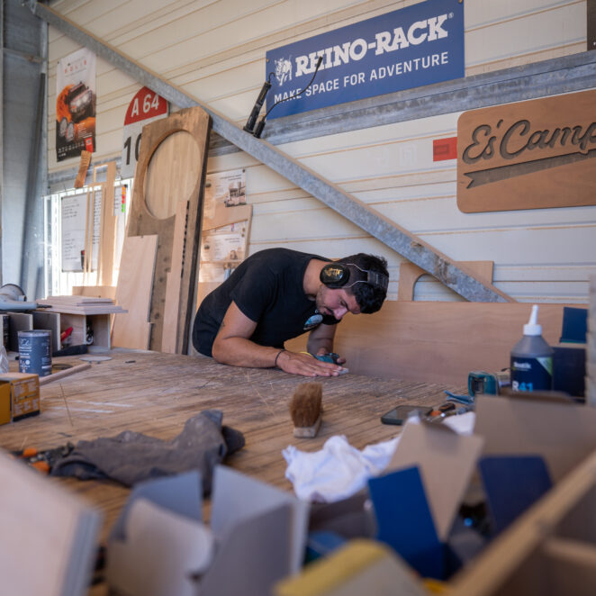 Jeune homme travaillant le bois avec un casque de chantier pour faire des créations 100 % faites à la main.