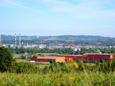 Vue sur le bassin de Lacq et ses usines avec un beau paysage au premier plan et en fond.