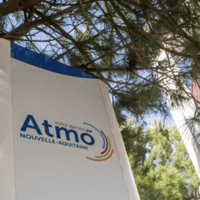 Totem présentant le bâtiment d'Atmo Nouvelle Aquitaine située sous un arbre laissant apparaître un grand ciel bleu.
