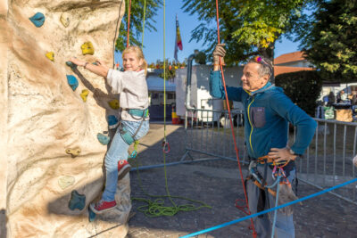Jeune fille qui monte sur un mur d'escalade entièrement équipée avec le gérant de l'activité également équipé, qui la maintien par une corde de sécurité. - Agrandir l'image 8 sur 9, fenêtre modale