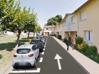 Vue après travaux avec des nouvelles places de stationnement de la rue montaigne. La route et le sens de circulation sont face à nous en vertical et les places de stationnements sont matérialisées à gauche avec des voitures garées, tandis qu'à droit une personne et son enfant marche sur le trottoir neuf.