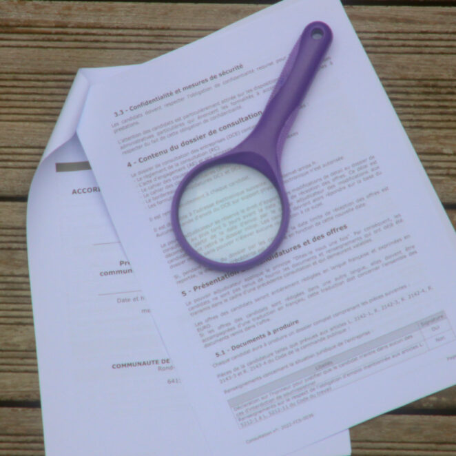 loupe posée sur un document de consultation pour les marchés publics