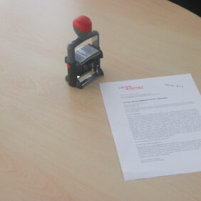 Sur une table est posée une délibération imprimée et tamponnée pour prouver sa validité.